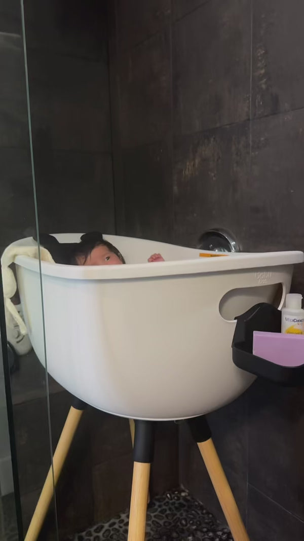 Baby sitting comfortably in the elevated Babu Bath with head support pillow.